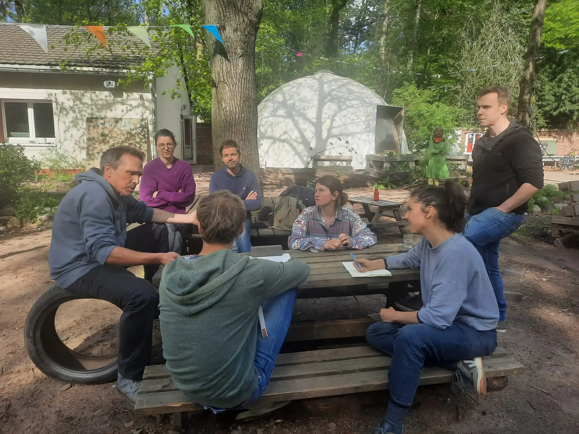 People sitting outside around a table in conversation